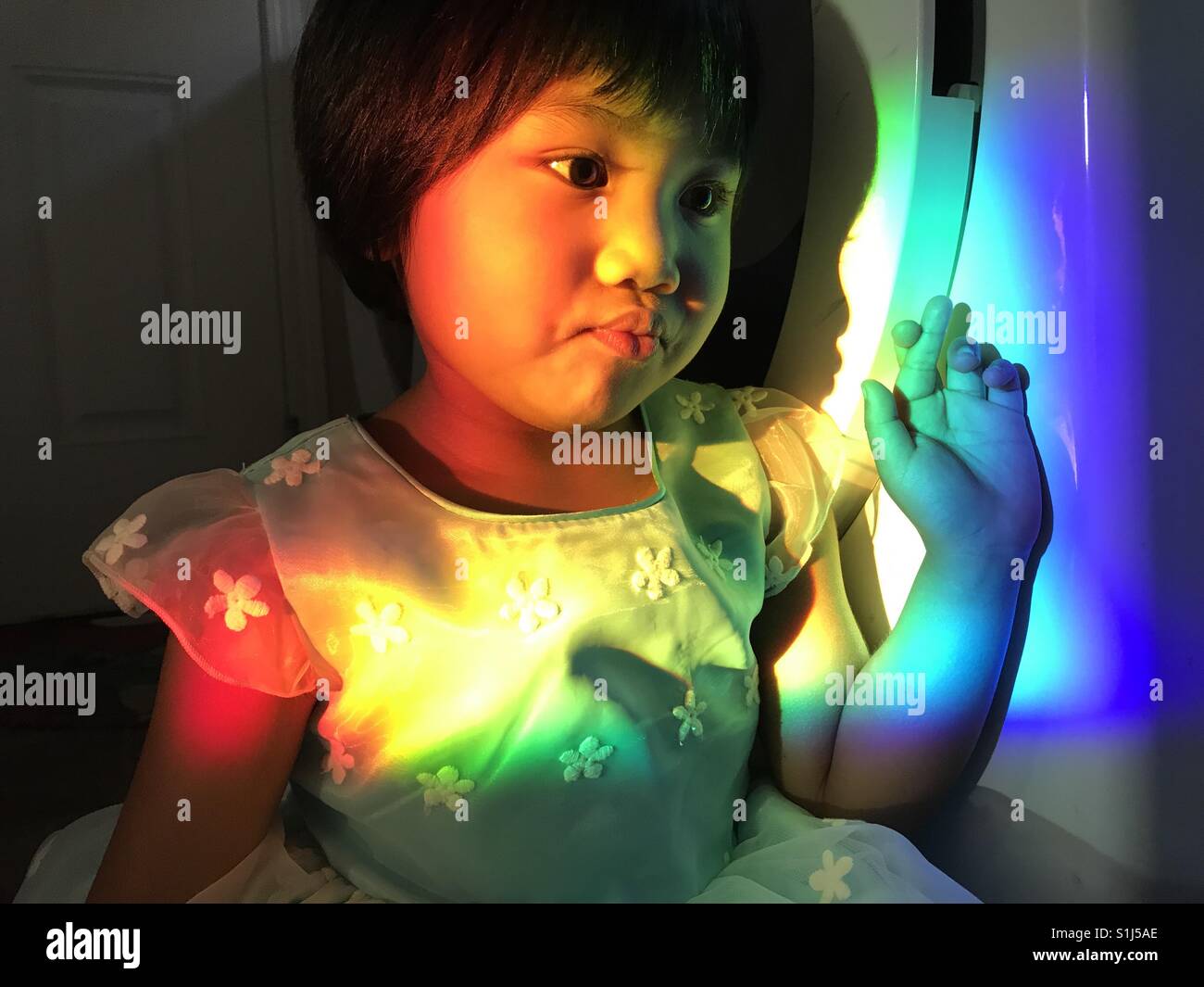 Rainbow girl with heart shaped fingers Stock Photo