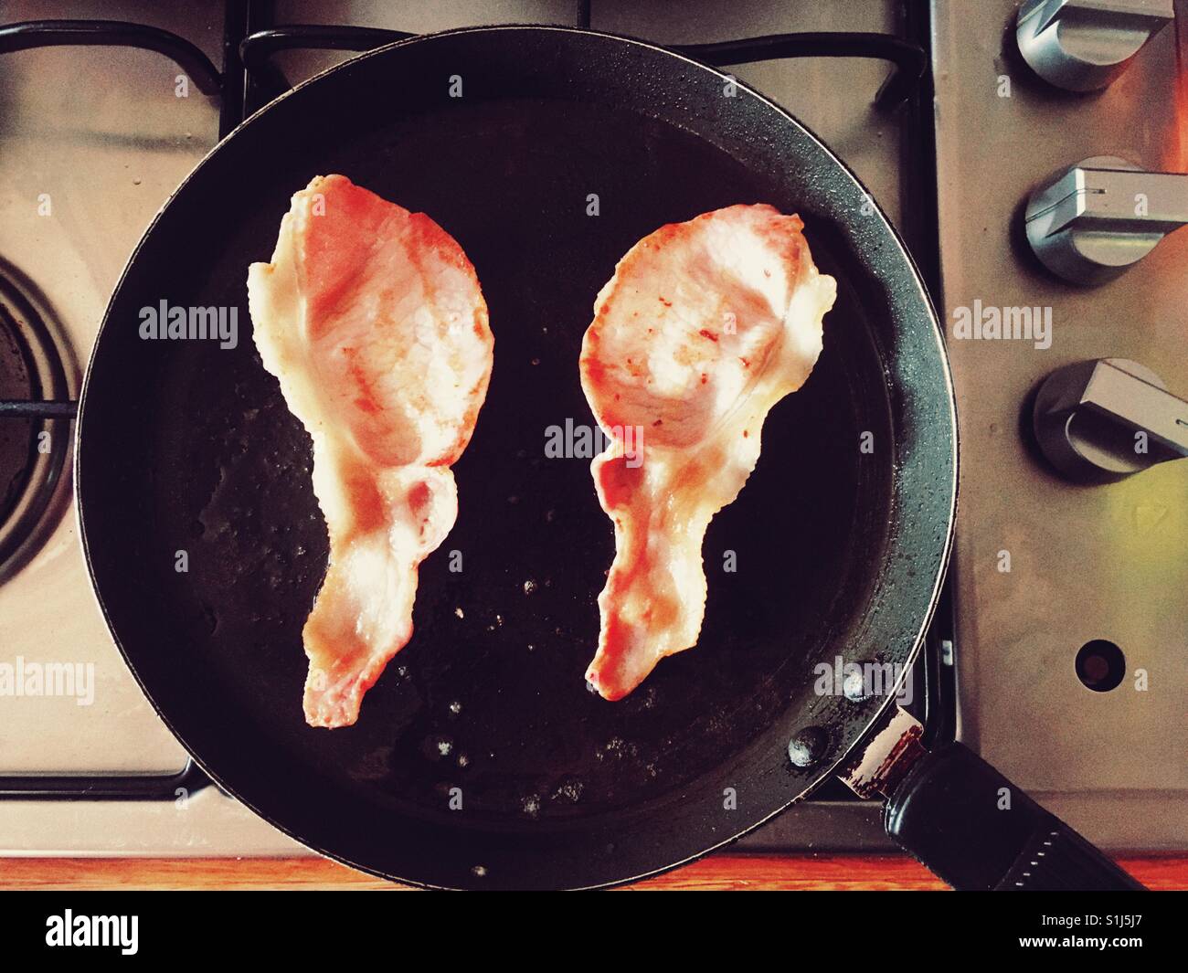 Bacon cooking in a frying pan Stock Photo - Alamy