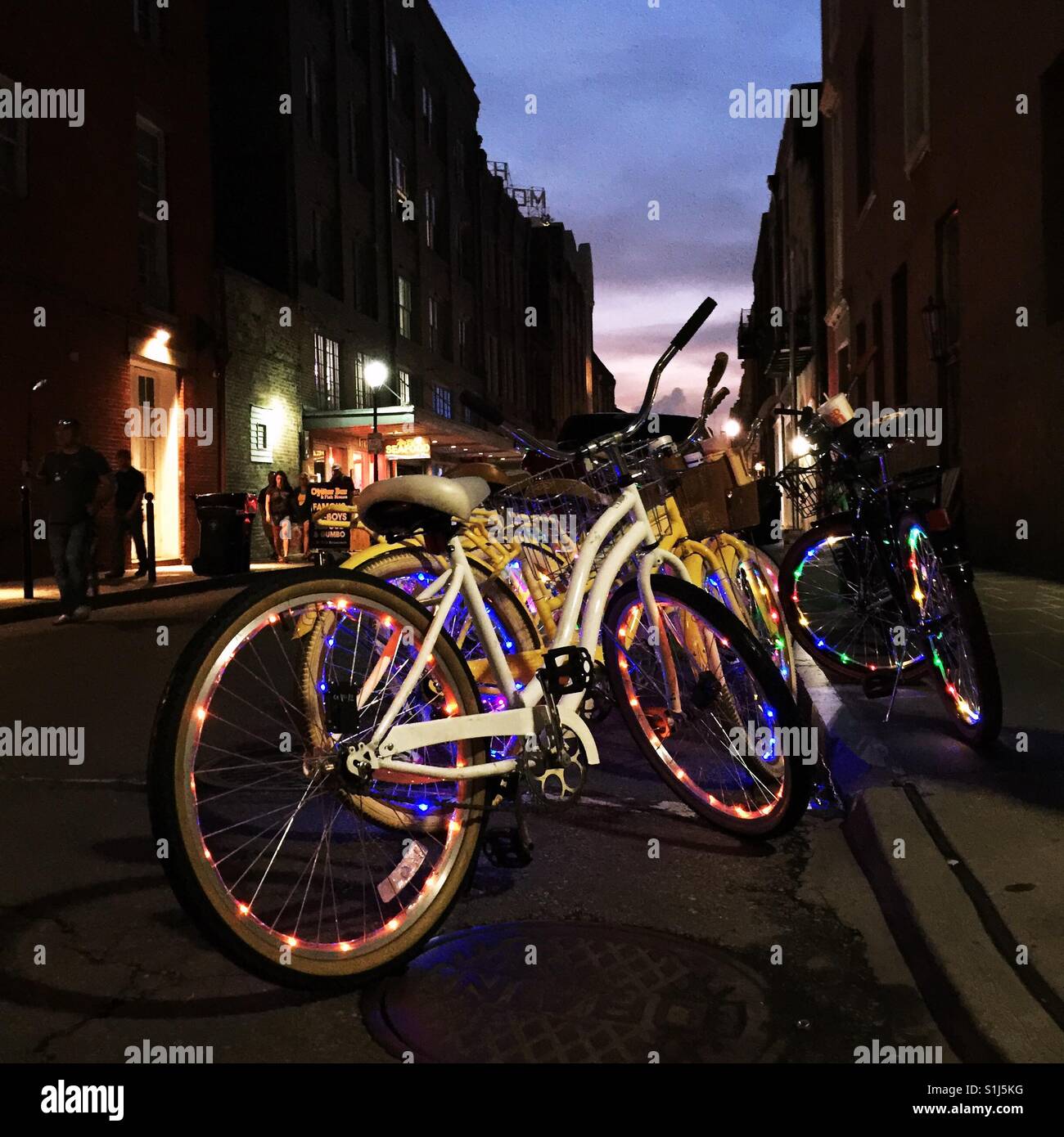 String lights decorate wheels of rental bikes in French Quarter in New Orleans at night Stock Photo