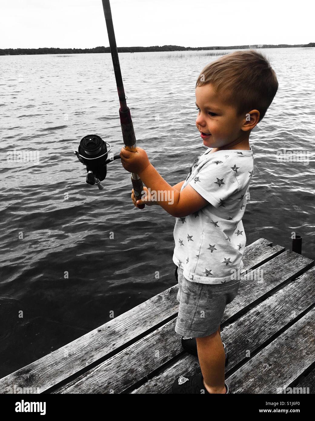 Toddler fishing from the dock for the first time Stock Photo