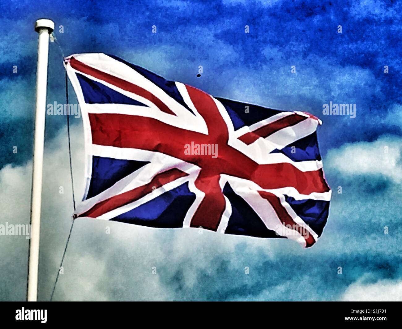 Union flag flying against blue sky with white clouds on a summer day - Smartphone Captured Stock Image