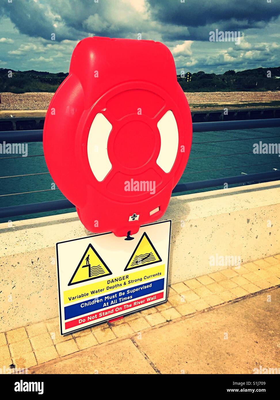 Bright red lifebuoy with warning sign on Littlehampton promenade - Smartphone Captured Stock Image
