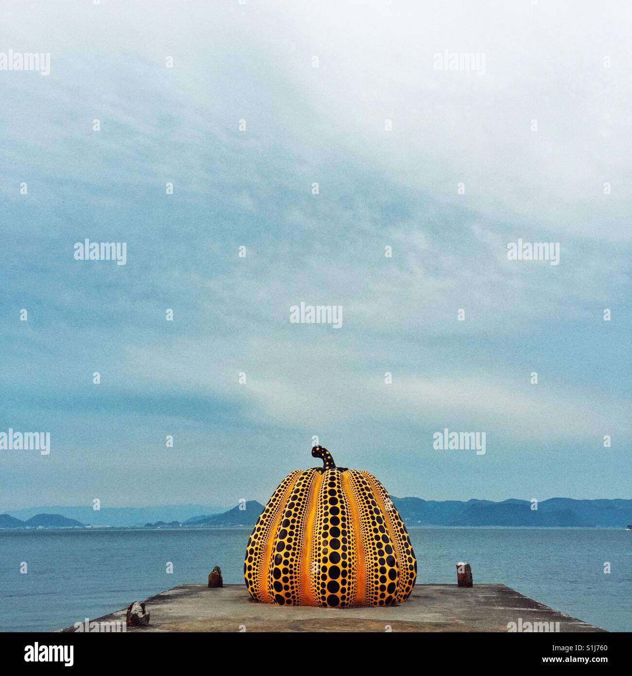 Famous yellow pumpkin with black dots by Japanese artist Yayoi Kusama installed on the pier on Naoshima Island Stock Photo