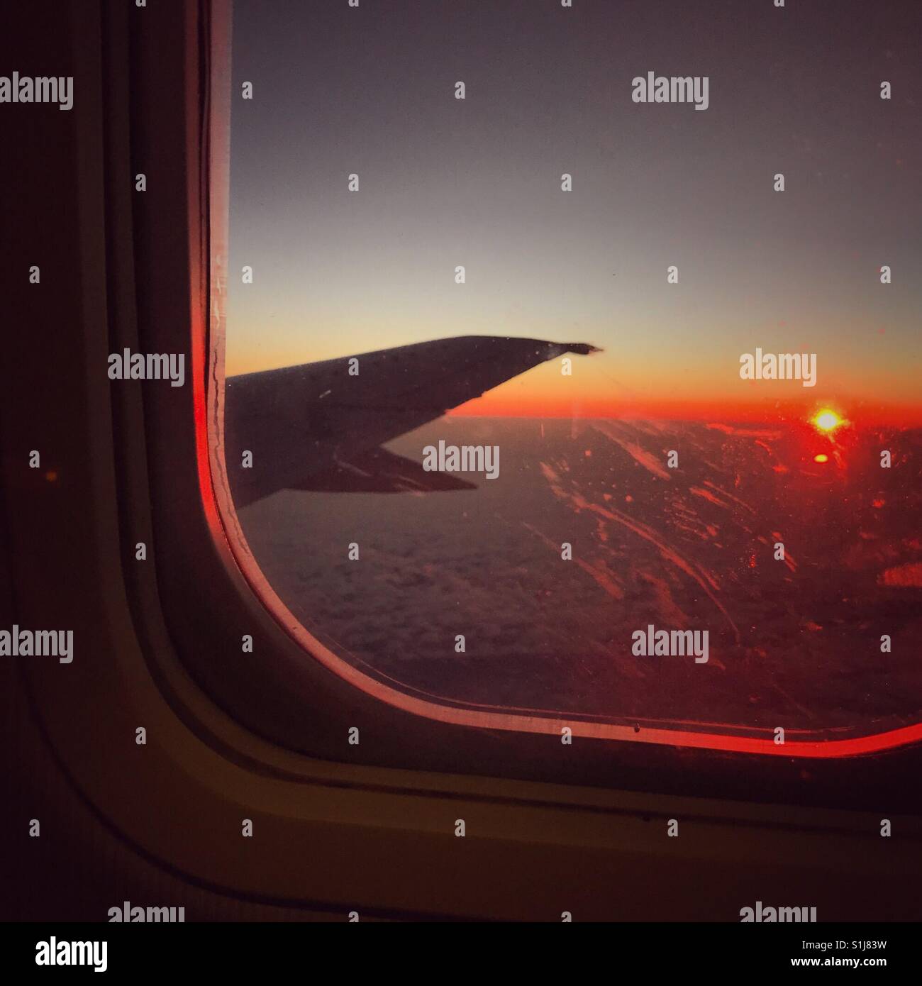 Sunrise through the dirty window of an airplane. - Smartphone Captured Stock Image