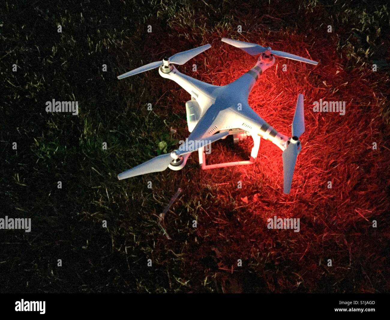 Camera drone on the grass at night ready to take off - Smartphone Captured Stock Image