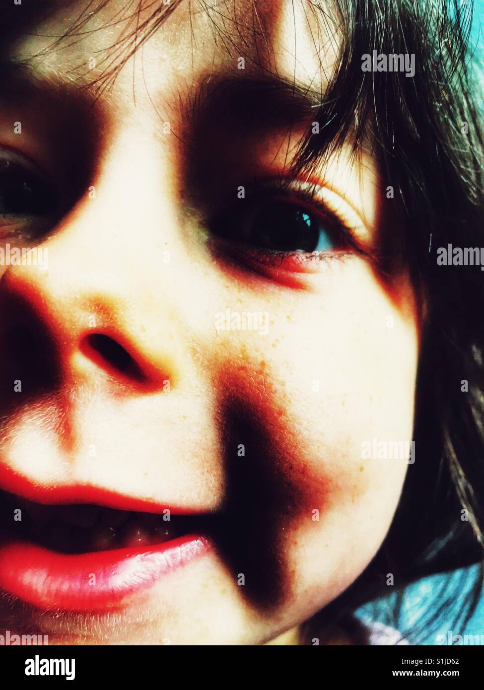 Effects of sugar rush on a 5-year old girl after eating sweets - Smartphone Captured Stock Image
