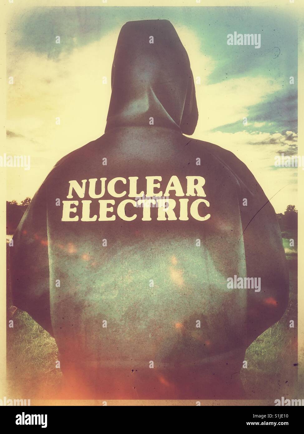 Figure in 1990's Nuclear Electric workers Parka at sunset. Stock Photo