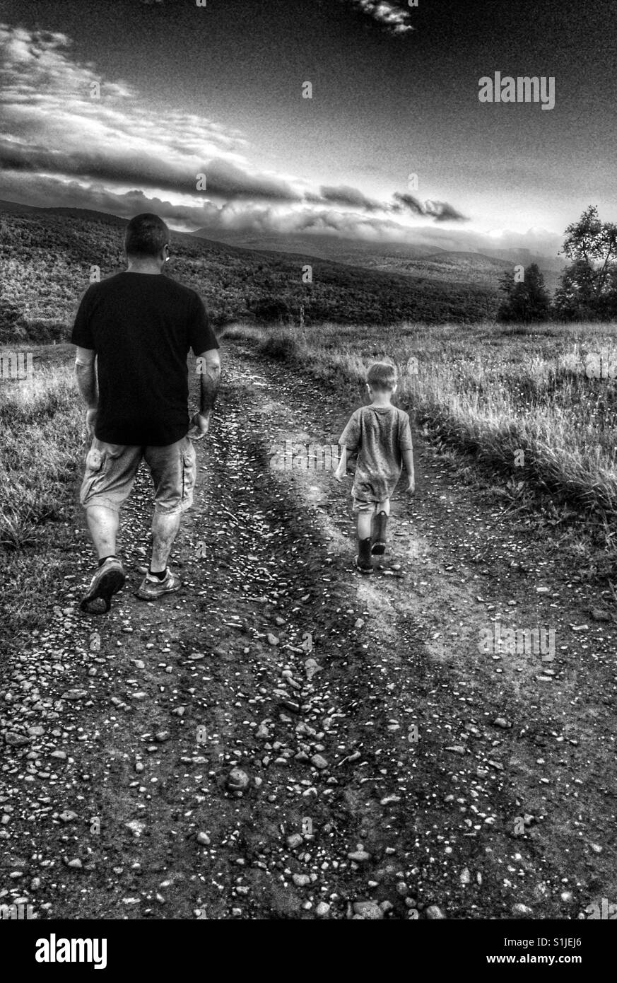 Grandfather and grandson walking in the countryside. Stock Photo