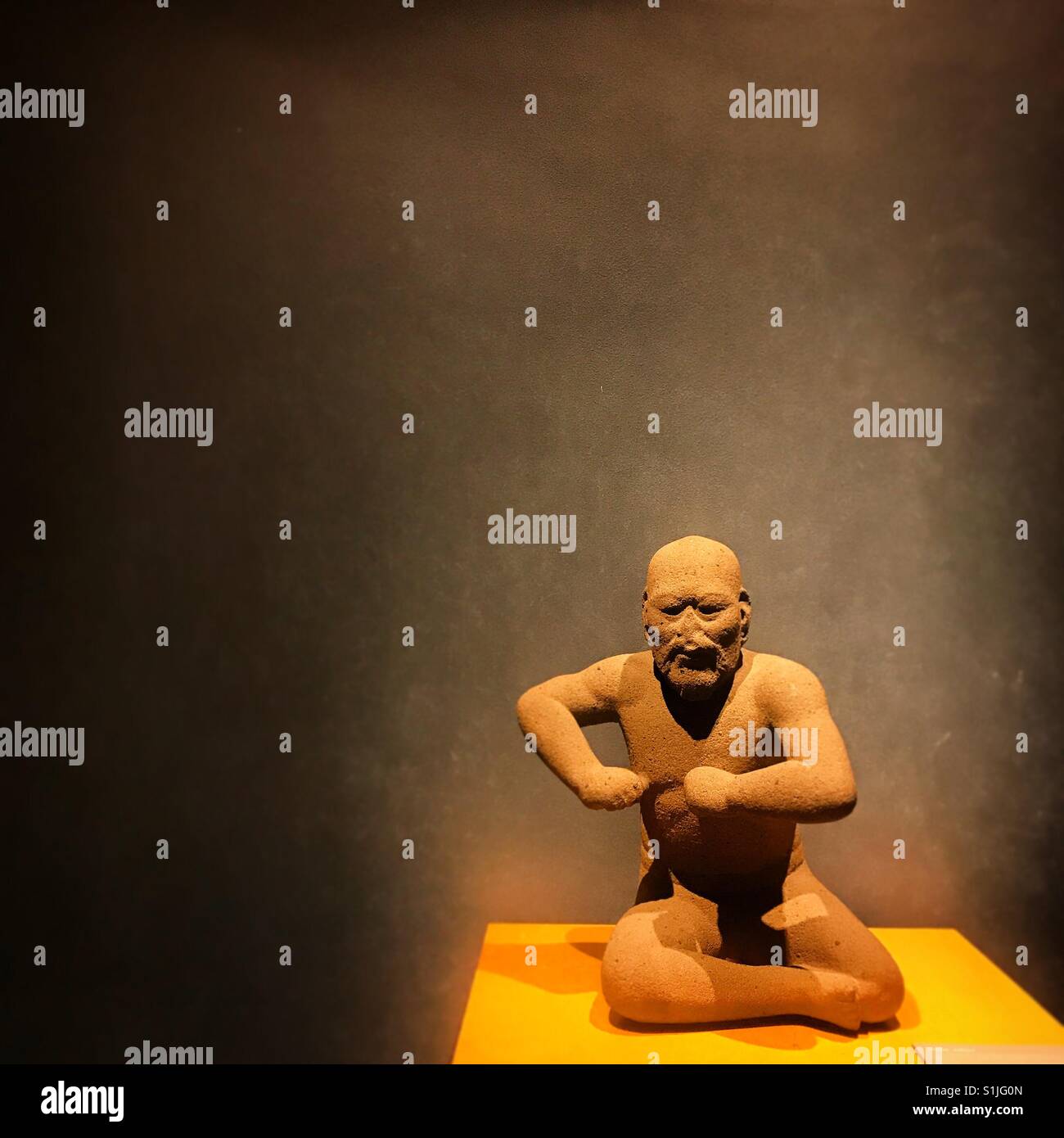 A sculpture of a man from the Olmec culture is displayed in the Museo Nacional de Antropologia e Historia en Mexico City, Mexico - Smartphone Captured Stock Image