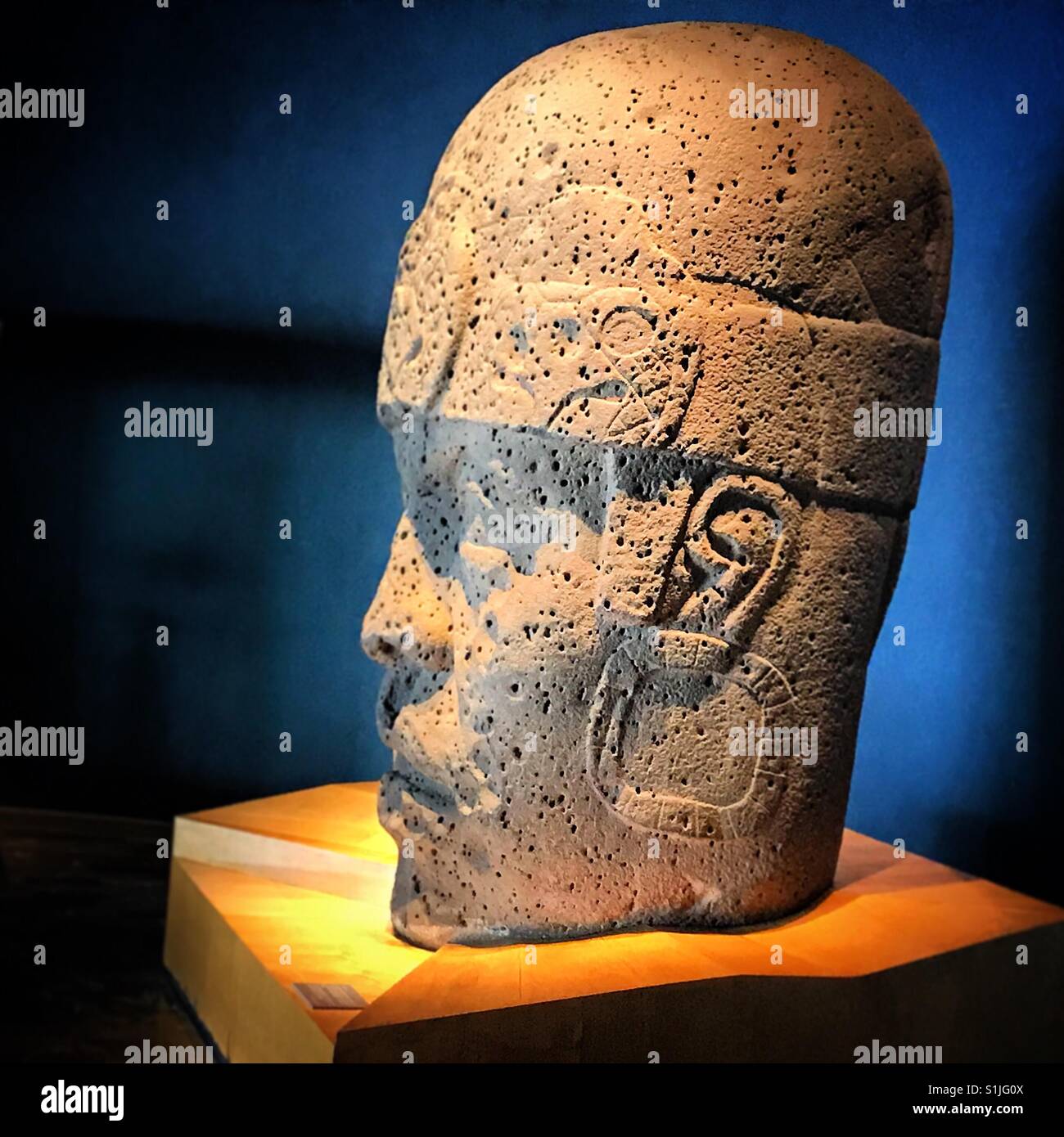 A giant head displayed in the Olmec room of the Museo Nacional de Antropologia in Mexico City, Mexico - Smartphone Captured Stock Image