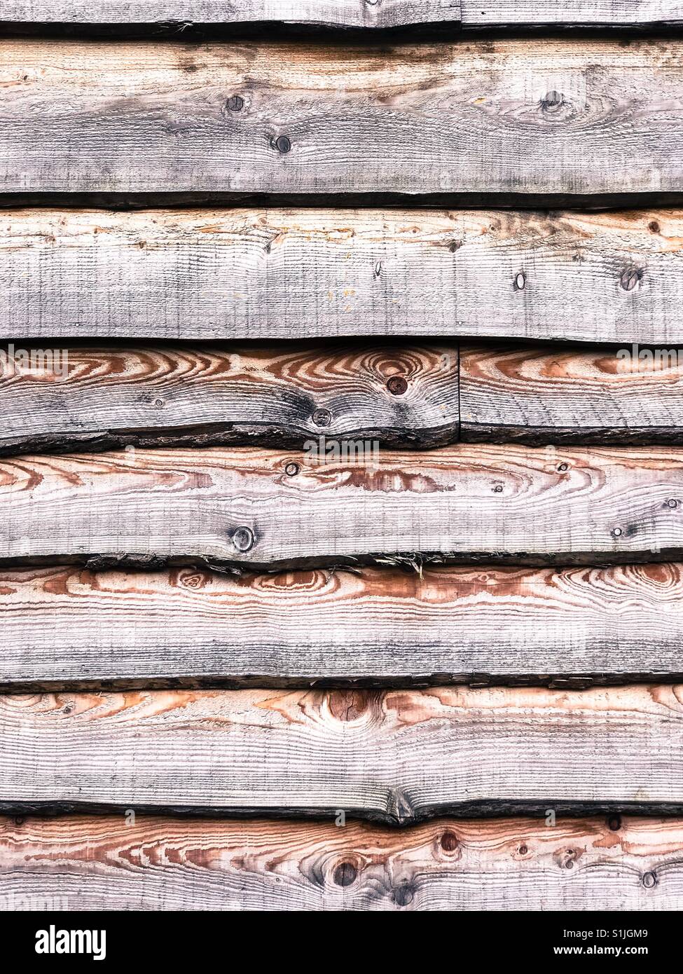 Rustic wood cladding on the side of a building. - Smartphone Captured Stock Image