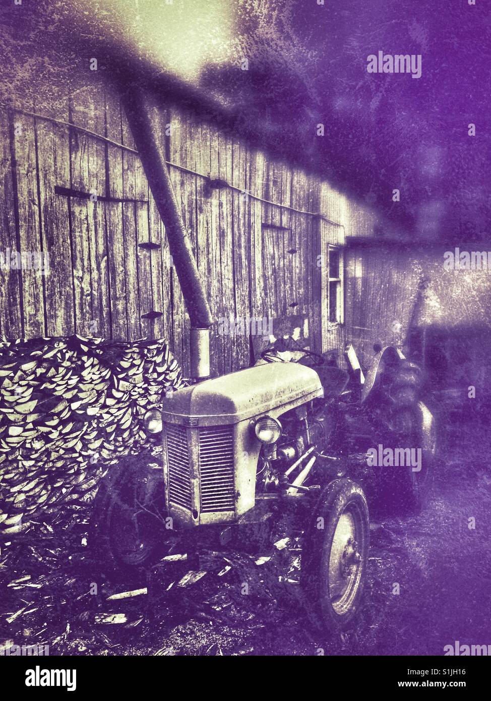 Old farm tractor grunge style. Stock Photo