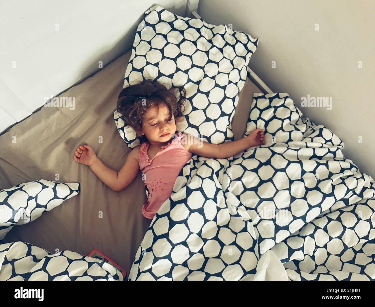 Litttle girl sleeping on a big bed - Smartphone Captured Stock Image