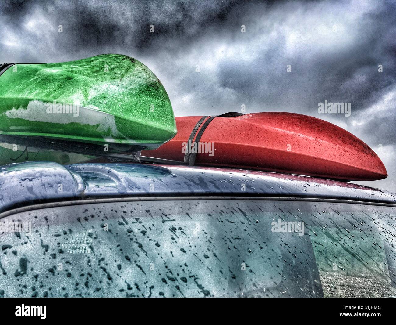 Canoes on top of van during downpour, Shingle Street, Suffolk, UK. - Smartphone Captured Stock Image