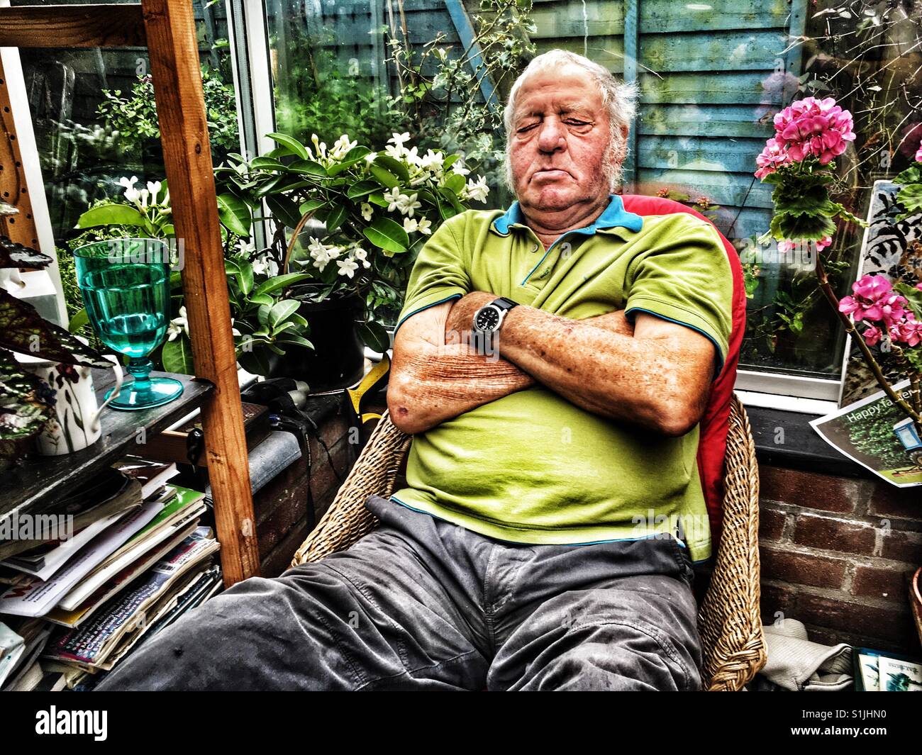 Elderly man asleep while sitting in a conservatory at his Suffolk home - Smartphone Captured Stock Image
