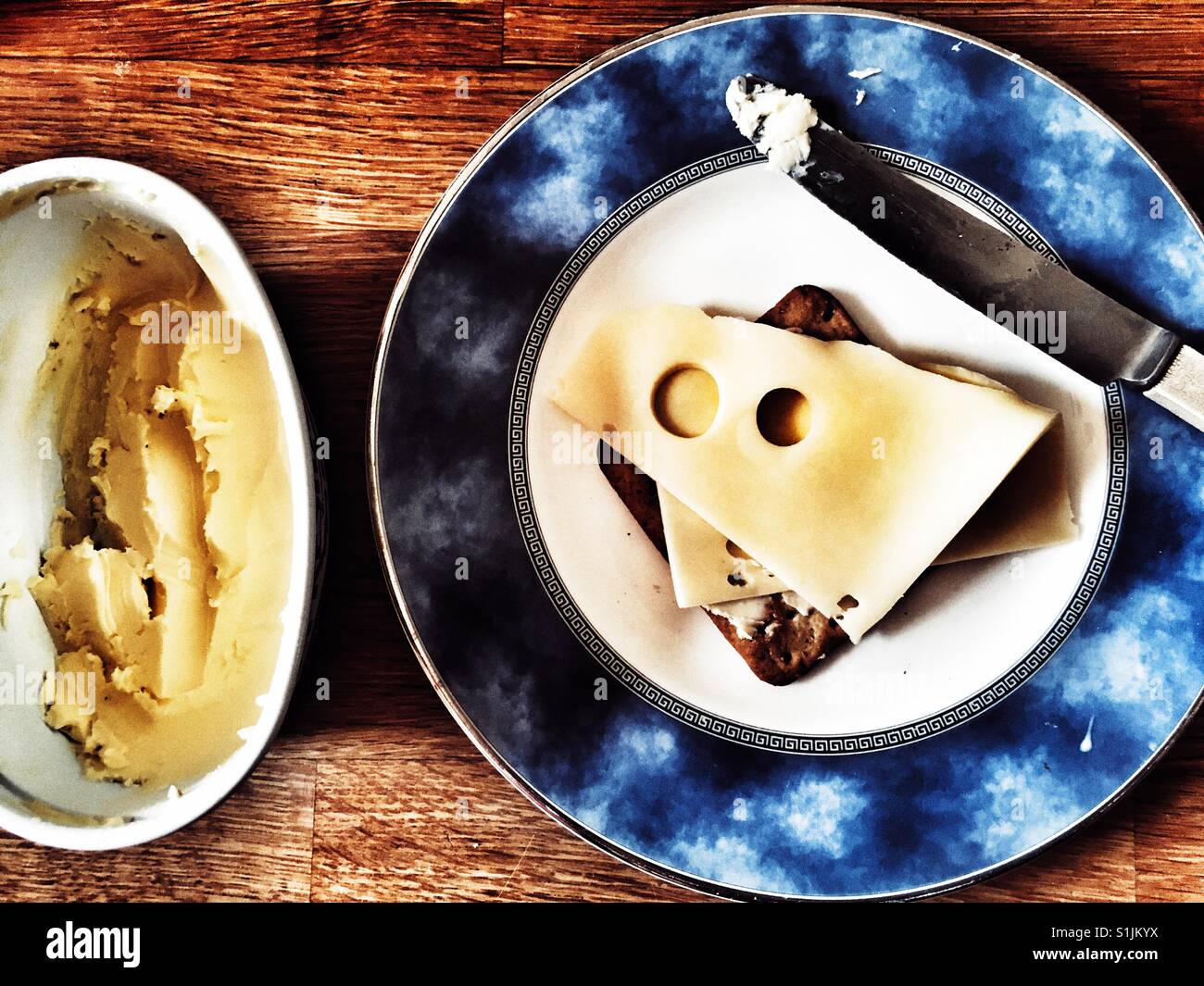 Jarlsberg sliced cheese on buttered cracker Stock Photo Alamy