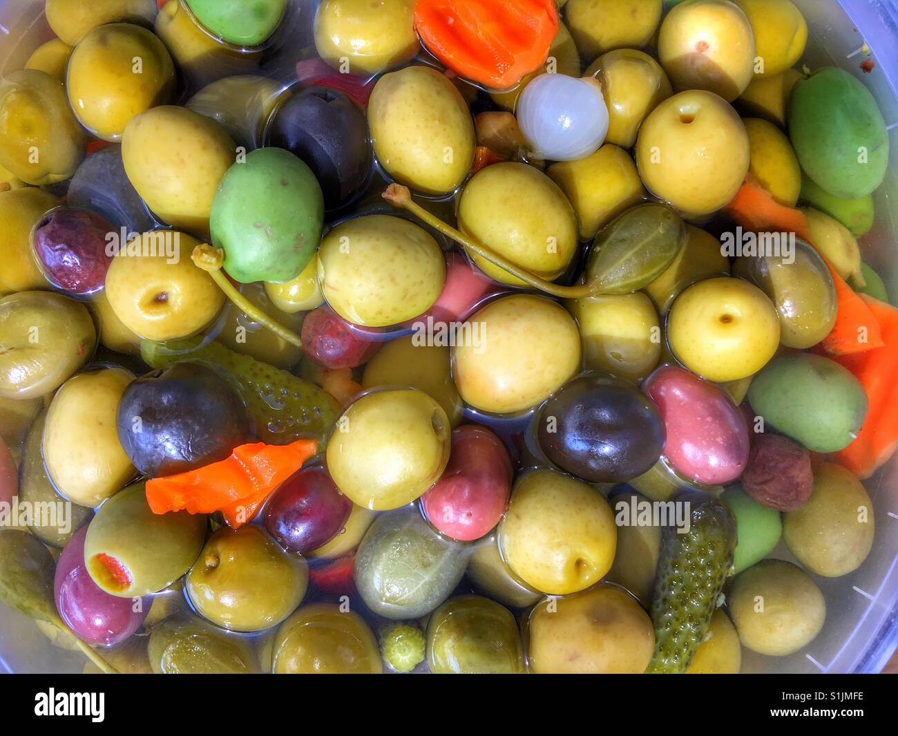 Mix of green and black olives, carrot, onion and capsicum for sale on a Spanish market stall - Smartphone Captured Stock Image