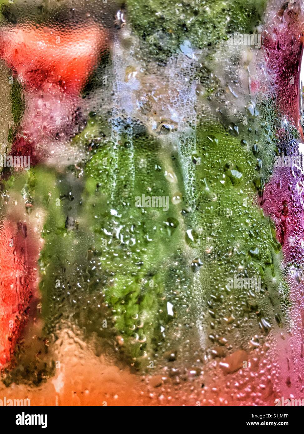 Abstract - detail of condensation on a glass jug of cold water with fresh lemon, mint leaves and strawberries. - Smartphone Captured Stock Image Abstract - detail of condensation on a glass jug of cold water with fresh lemon, mint leaves and strawberries. - Smartphone Captured Stock Image