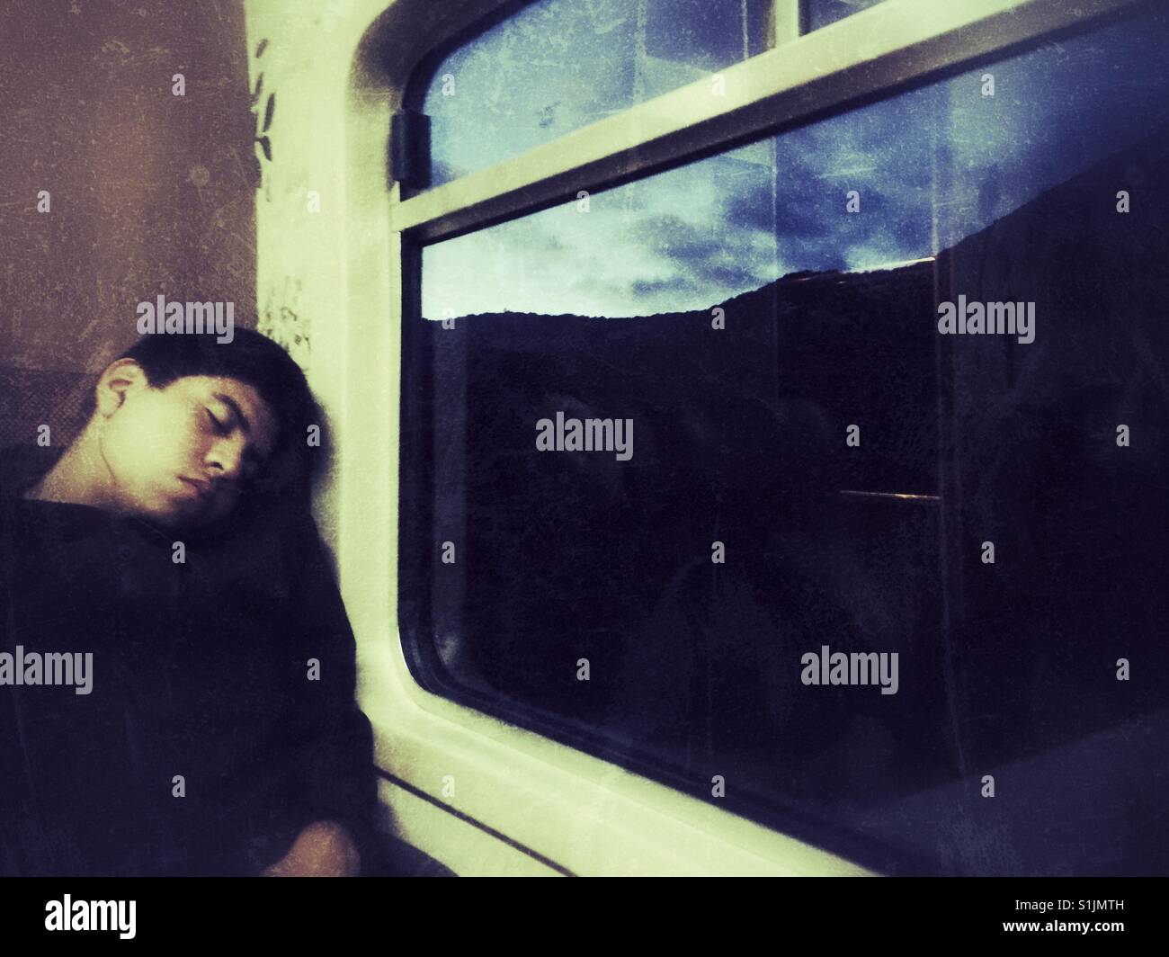 Young Peruvian man sleeping on the train to Machu Picchu - Smartphone Captured Stock Image