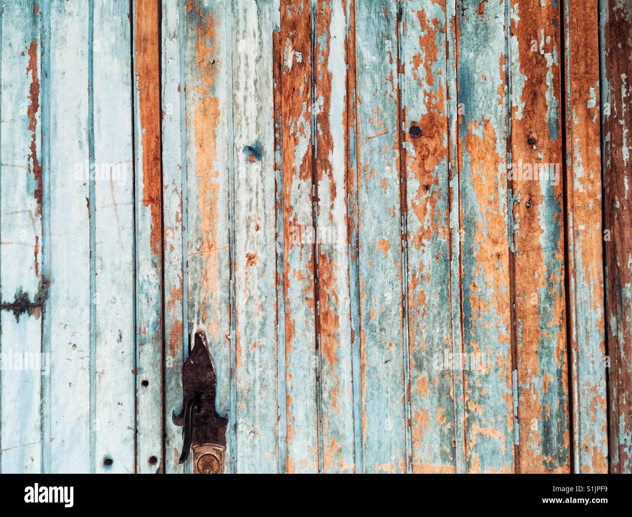 Peeling teal color paint on  wooden wall and the door in Peru Stock Photo