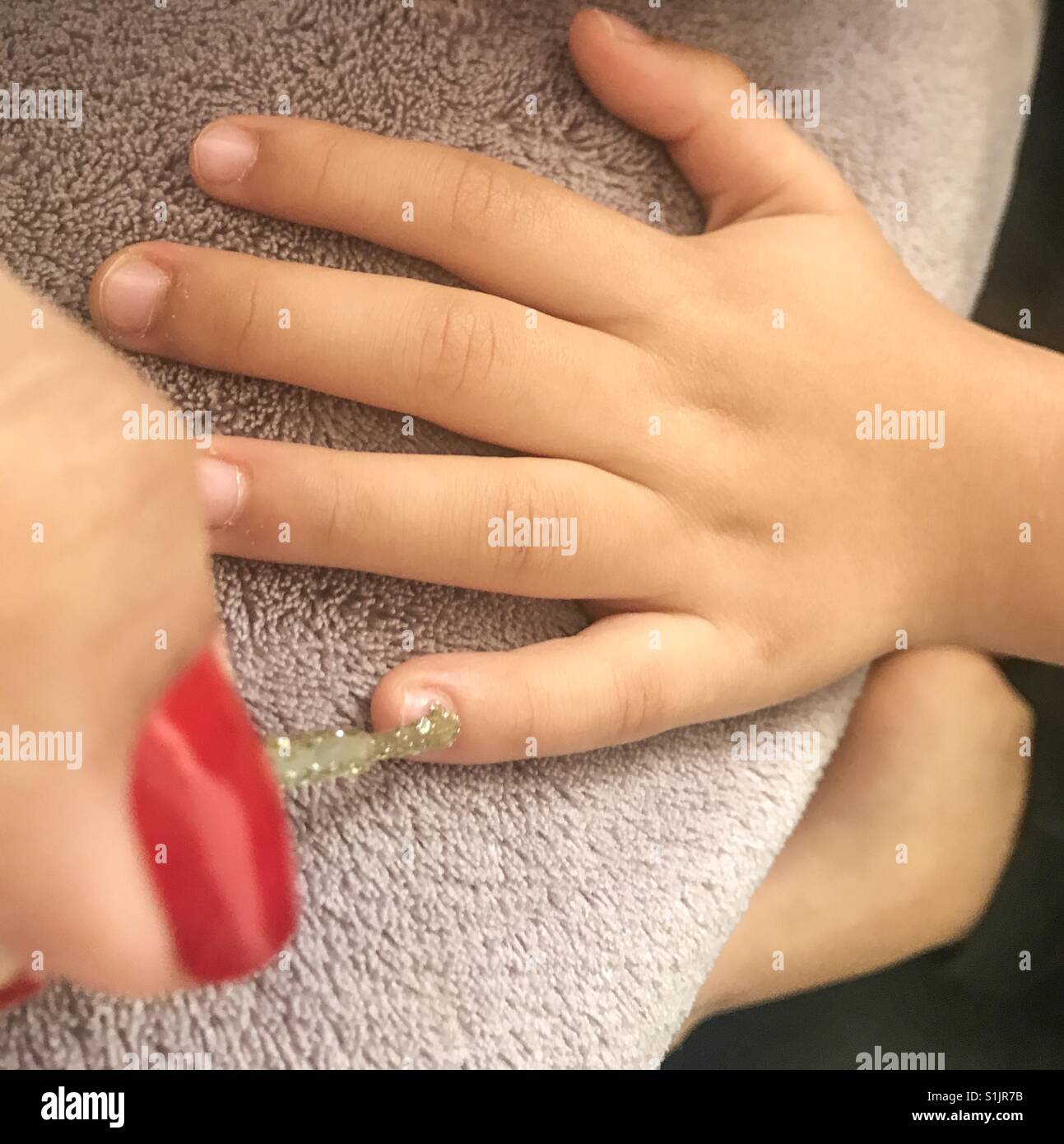 Mother's hand doing the daughter's nails - Smartphone Captured Stock Image