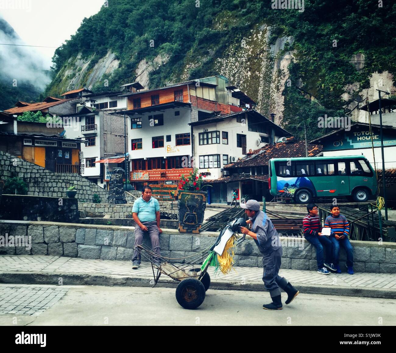 Everyday life goes by on the streets of Aguas Calientes, the jumping off point for Machu Picchu, Peru Stock Photo