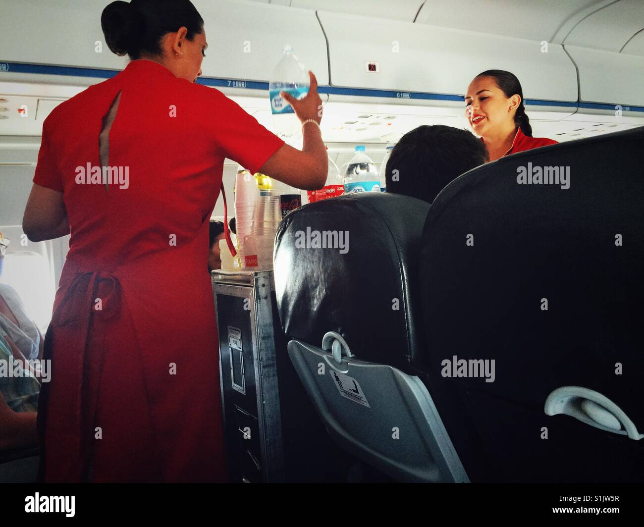 Flight attendants of Peruvian Air serving drinks on the plane from Lima to Cusco - Smartphone Captured Stock Image