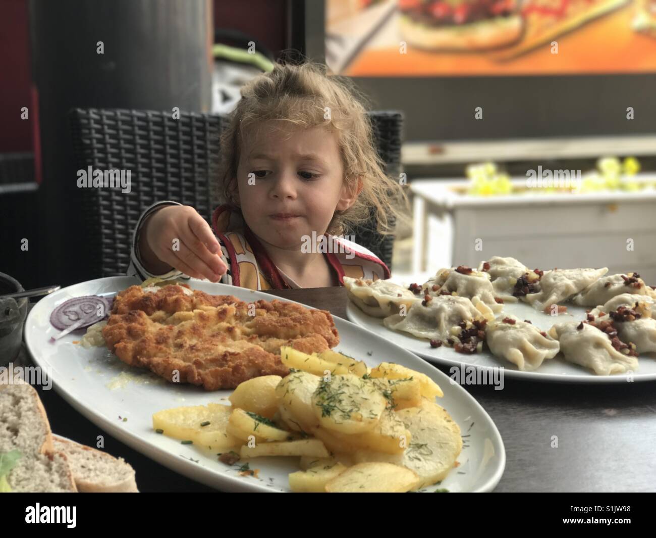 Little girl eating outdoors Stock Photo