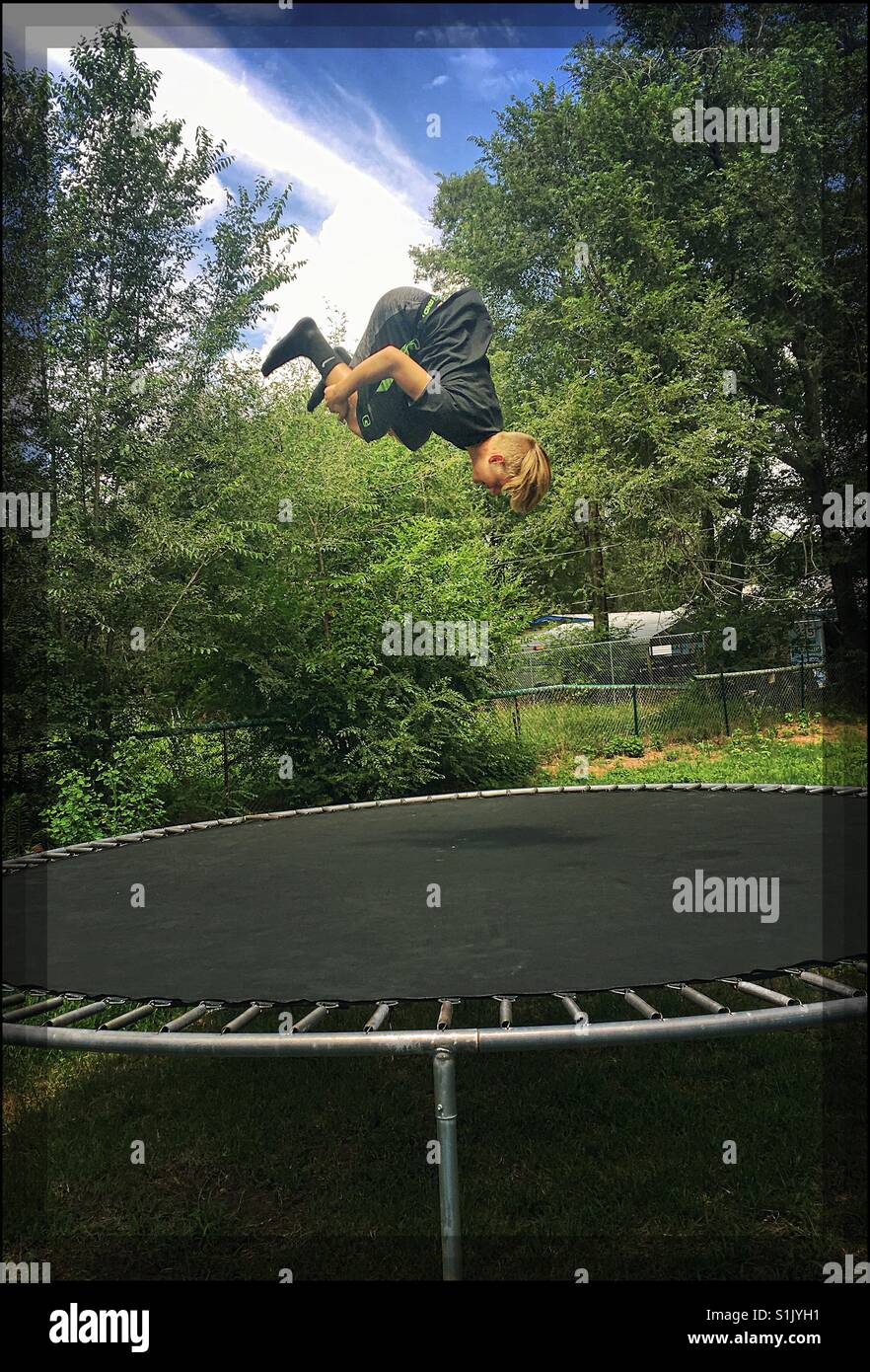 Teenage Boy Doing Flips On Trampoline Stock Photo Alamy