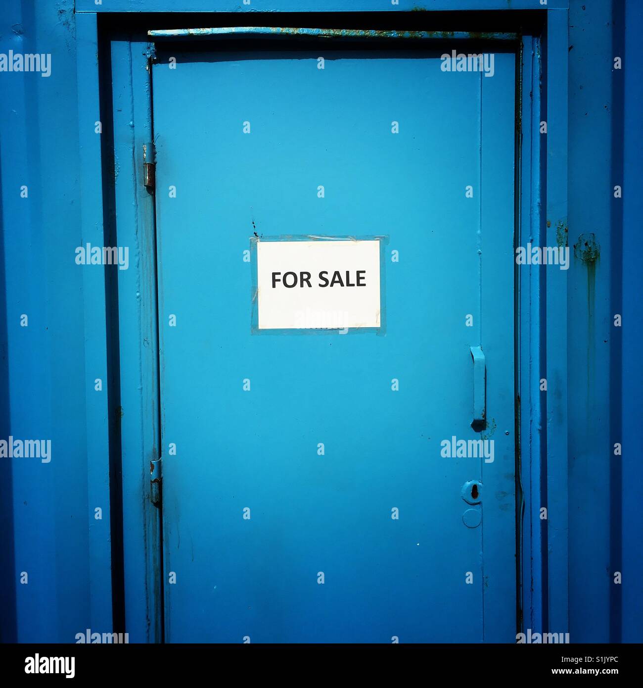 For Sale sign on a blue metal container door - Smartphone Captured Stock Image