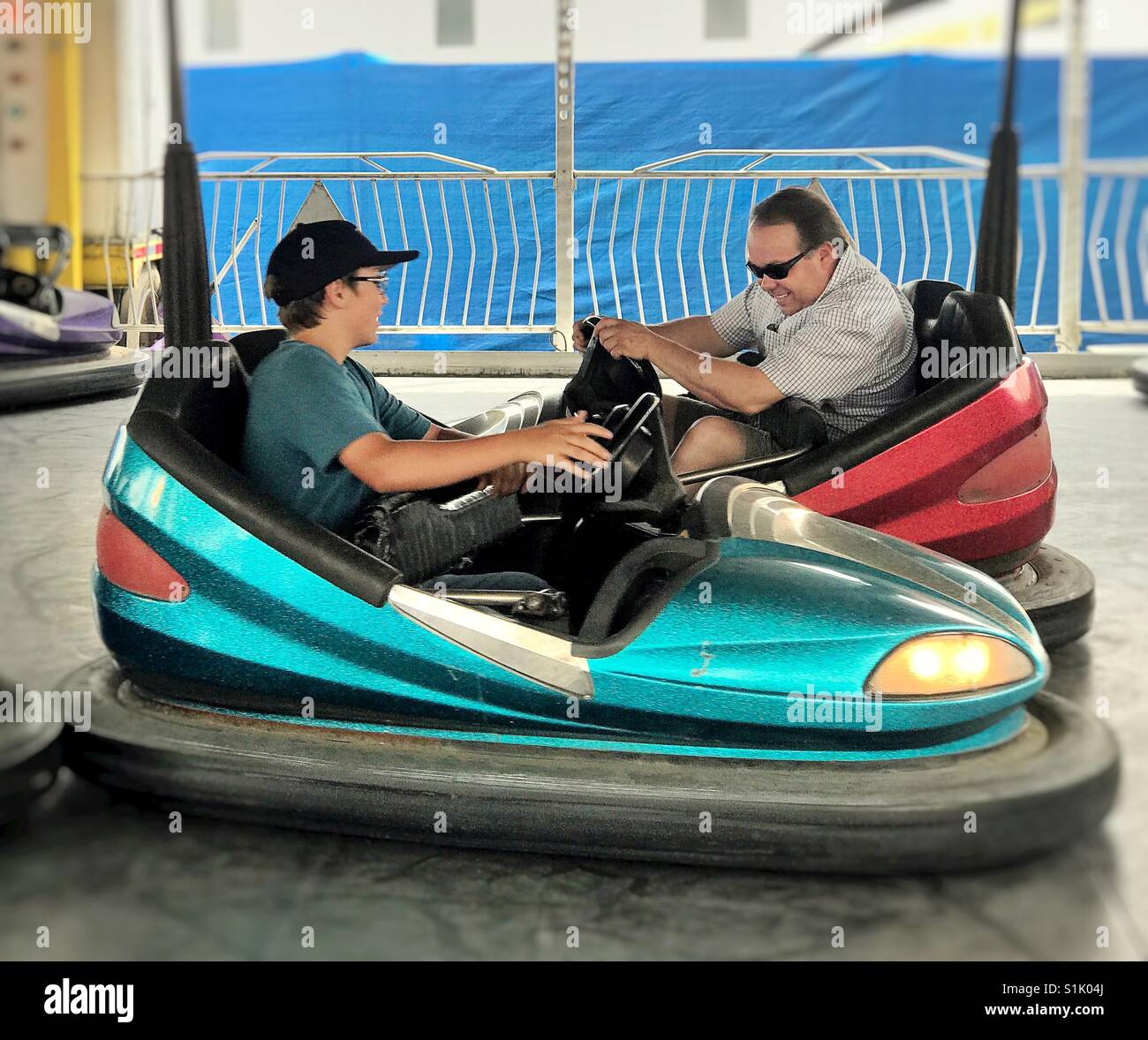 Father and son crash bumper cars. - Smartphone Captured Stock Image