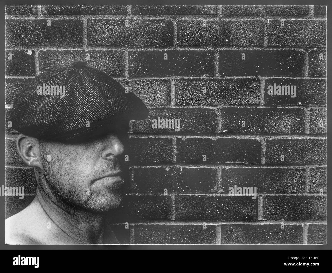 Man wearing a Peaky Blinders style sectional flat cap. Stock Photo
