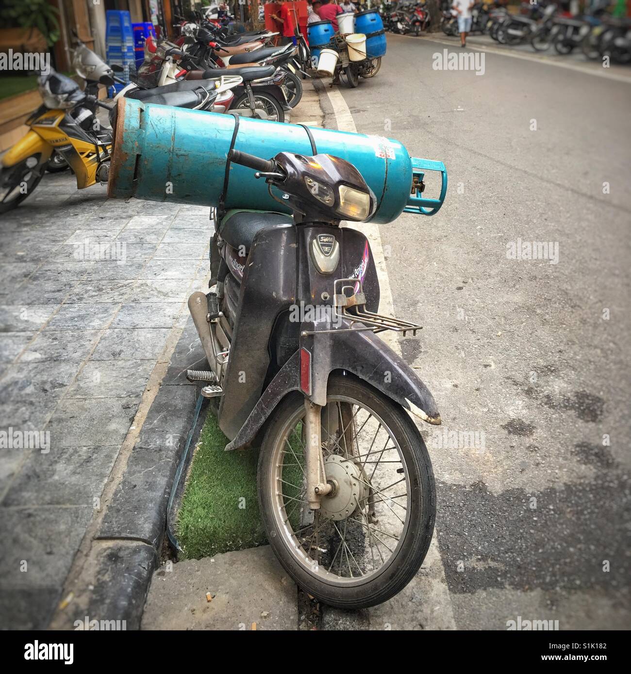 Large gas cylinder strapped to the back of a Vietnamese moped Stock Photo