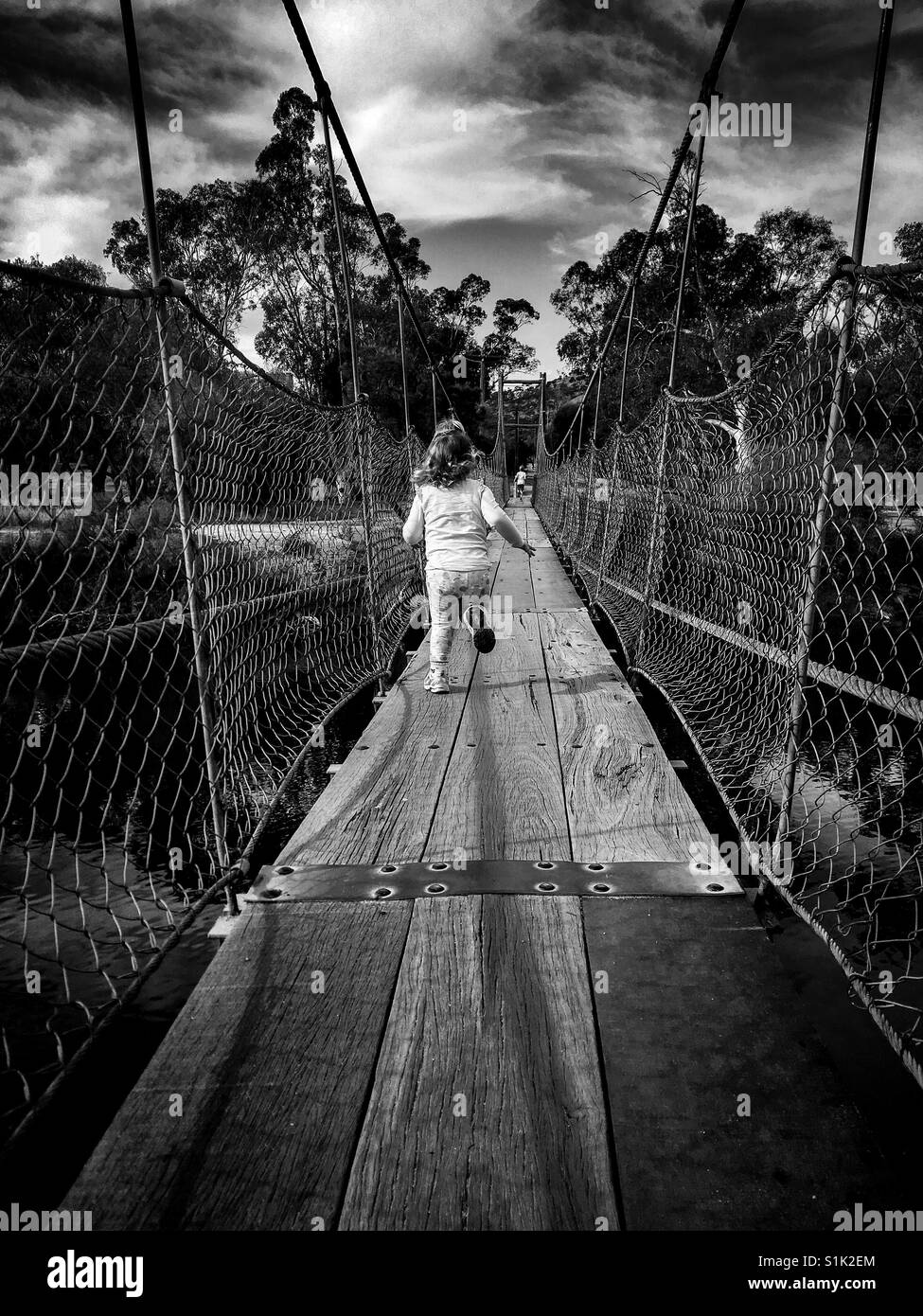 Running child across bridge Stock Photo