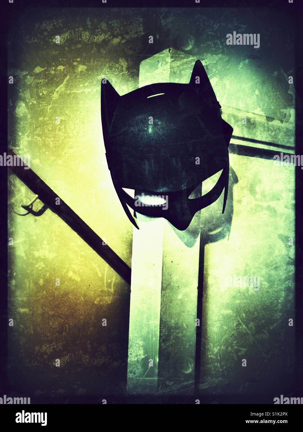 Batman mask hanging from a bannister in a family home. Stock Photo
