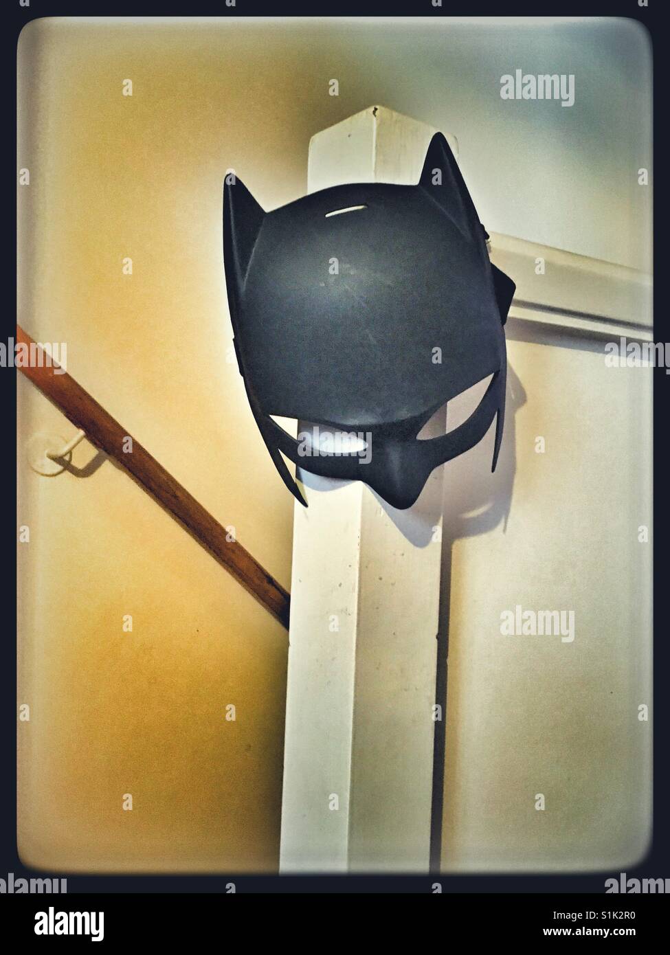 Batman Mask hanging at the top of a staircase. Stock Photo