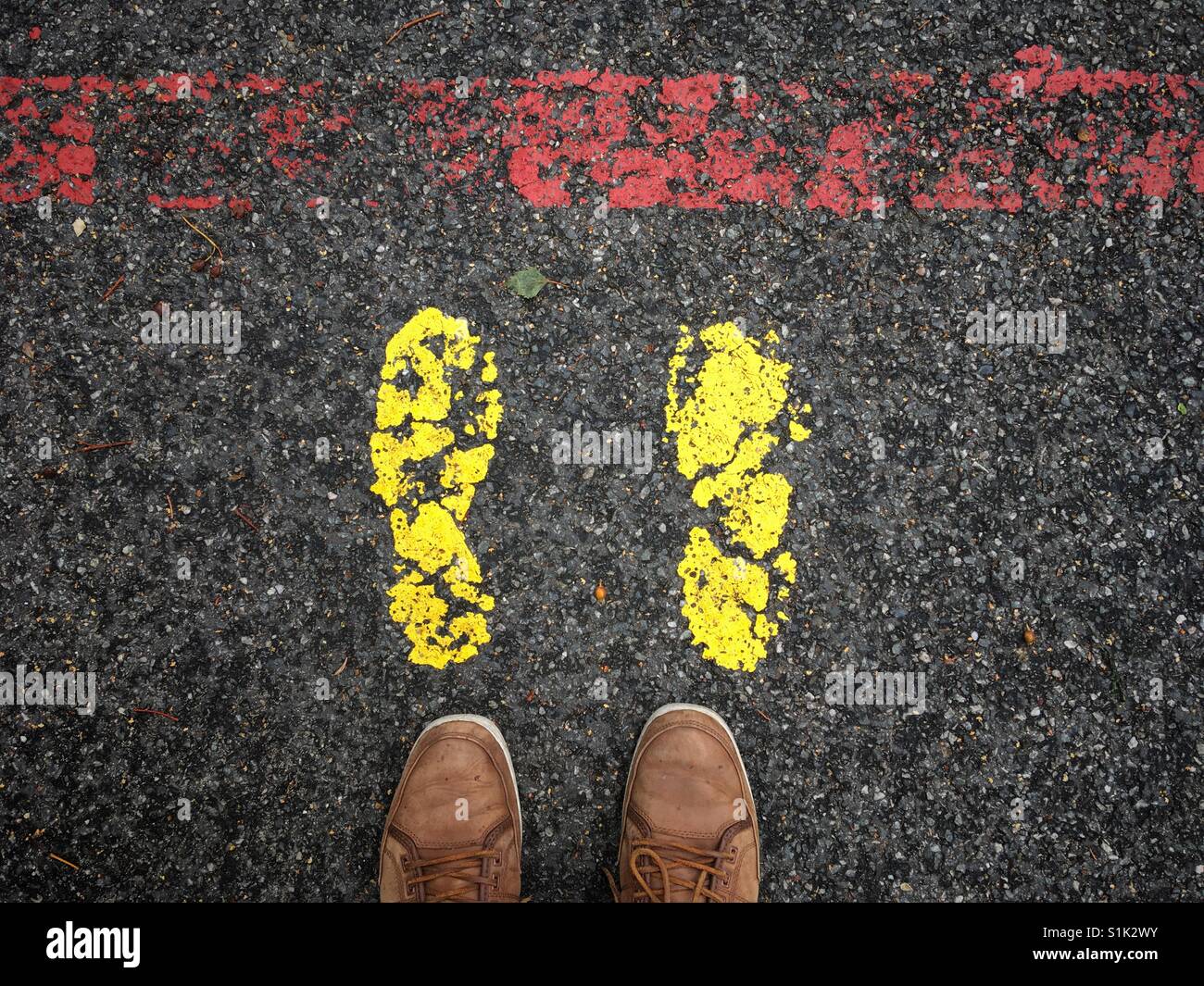 Feet markings and feet in front of a red line Stock Photo