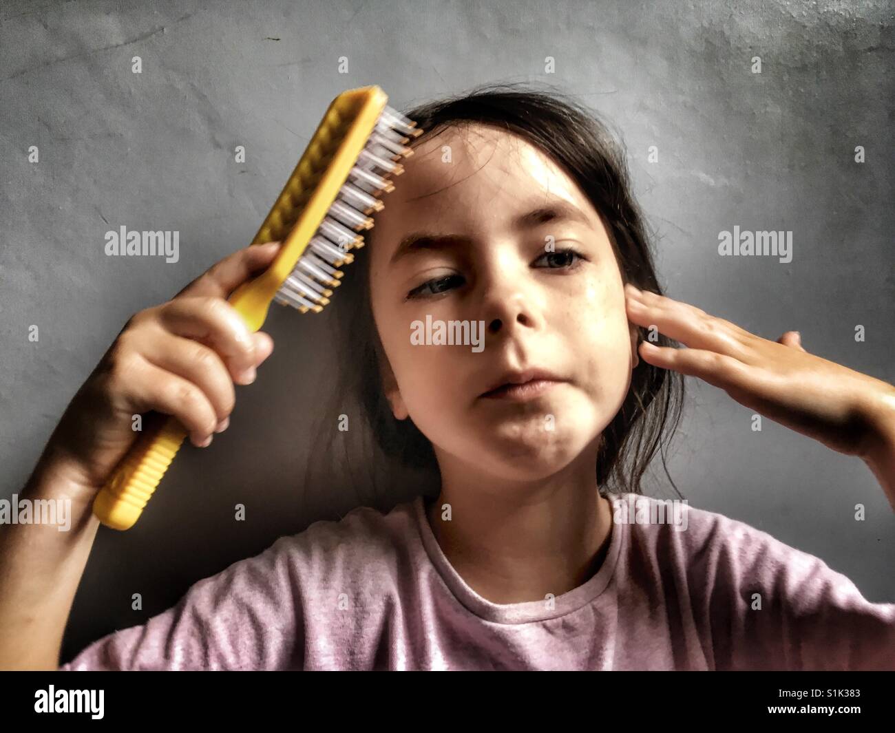 Child brushing her hair - Smartphone Captured Stock Image
