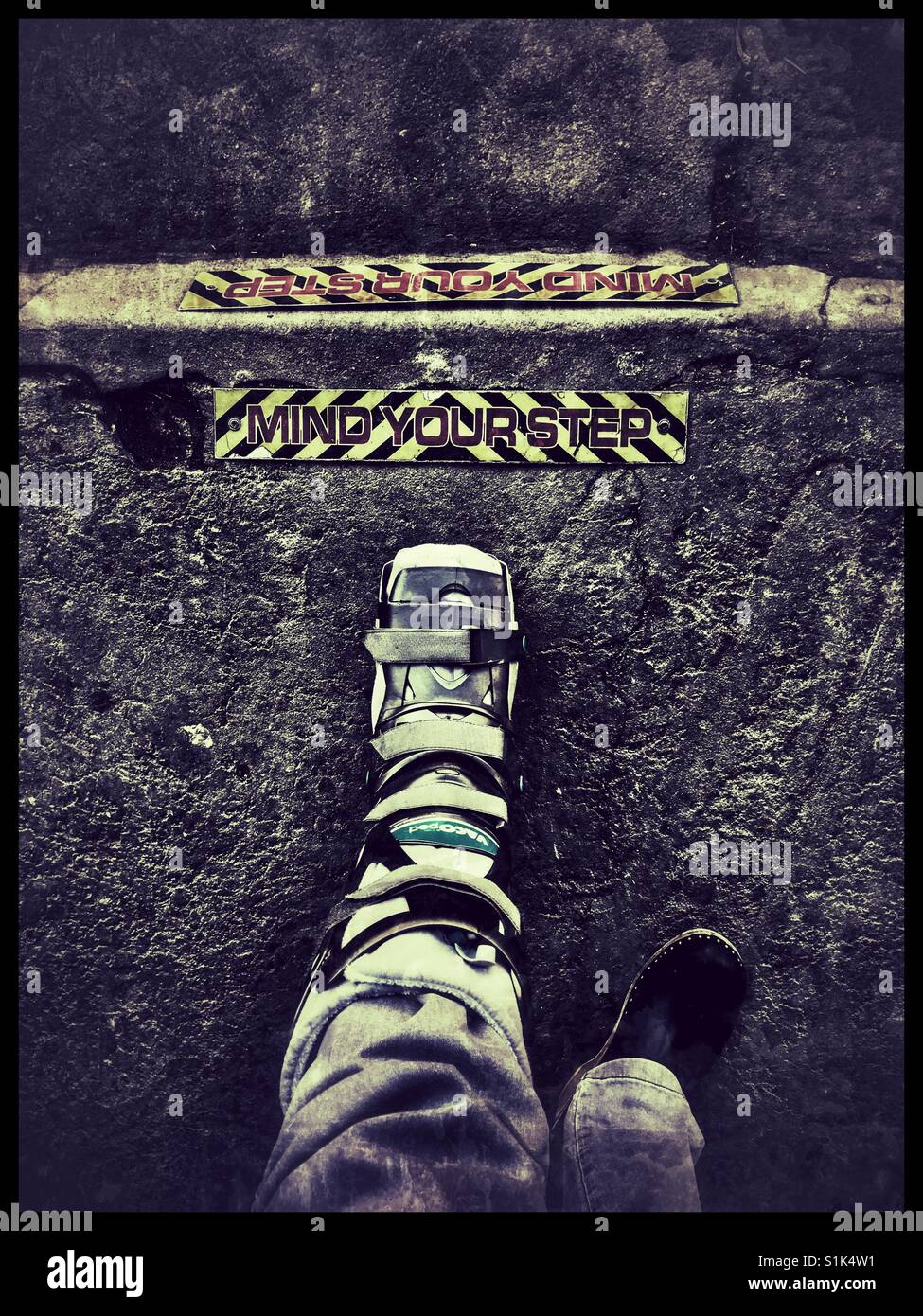 Mind your step sign on pavement. - Smartphone Captured Stock Image