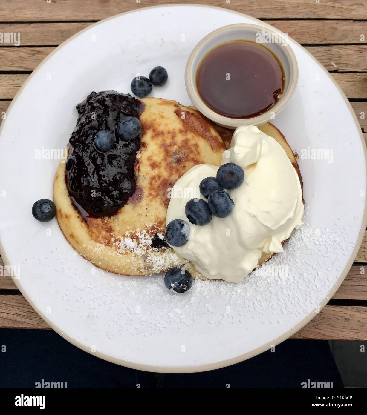 Blueberry Pancakes with creme fraiche, fruit compote and maple syrup Stock Photo