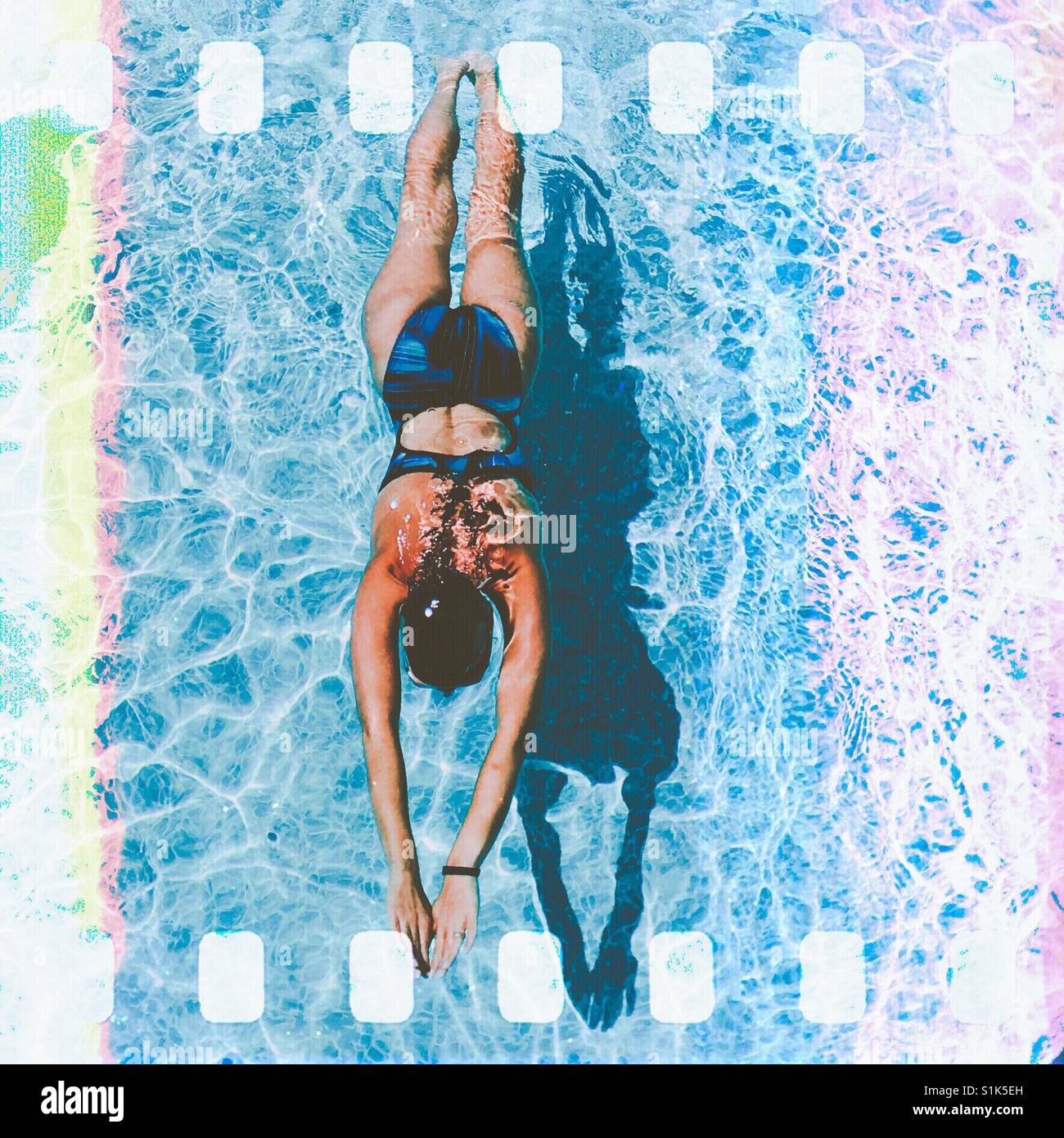 Woman swimming in pool. Square crop. Light leaks. Film effect. - Smartphone Captured Stock Image