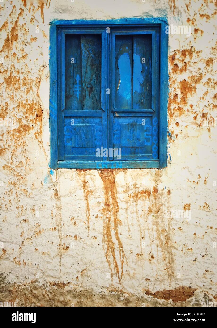 Bright blue painted window with close shutters on an old stucco wall in Cusco, Peru - Smartphone Captured Stock Image