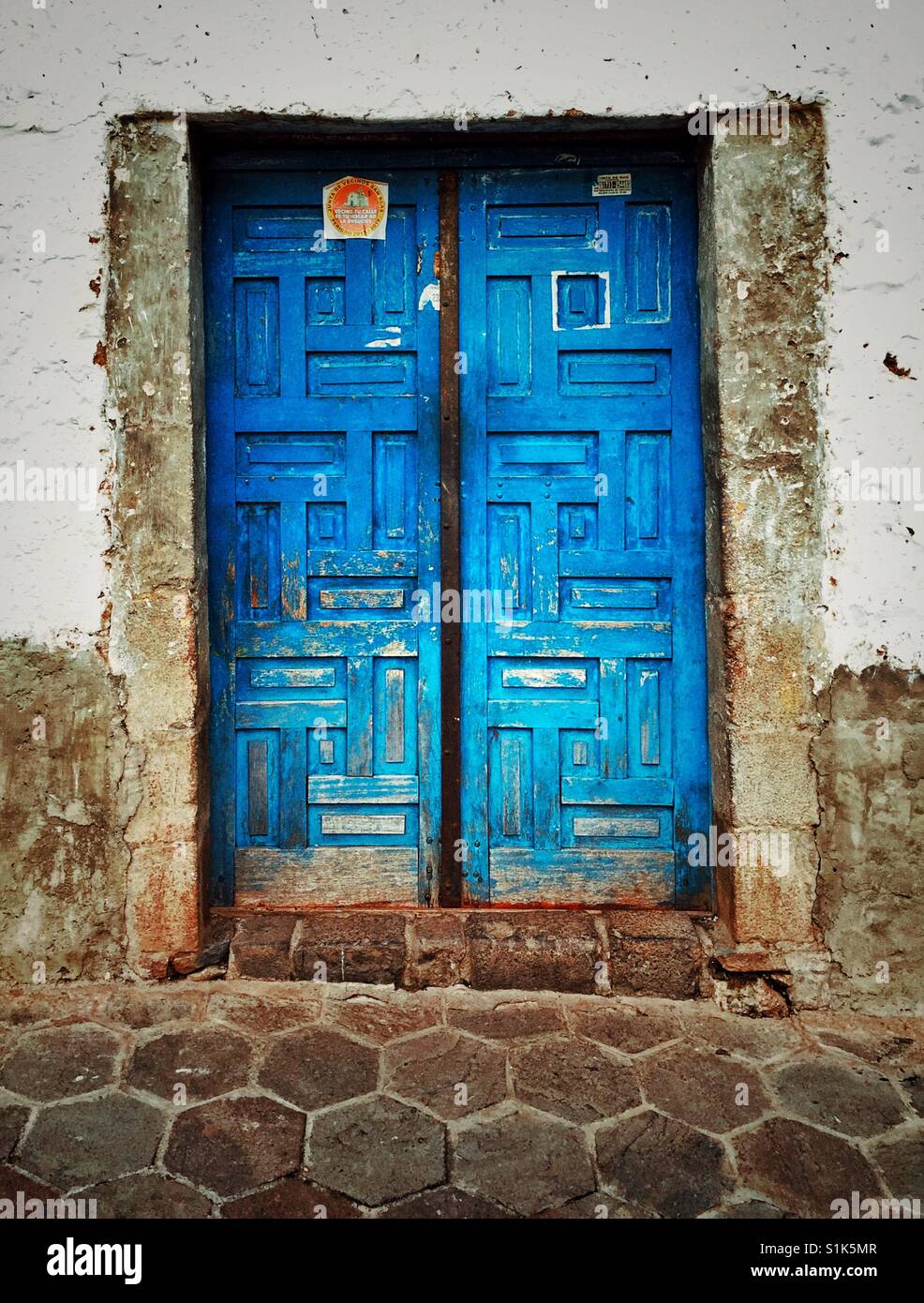 Old weathered double door made of wood and painted bright cobalt blue in Cusco, Peru Stock Photo