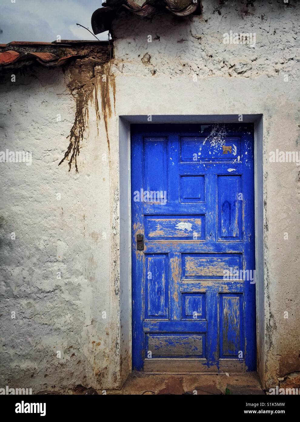 Old weathered door made of wood and painted bright cobalt blue in Cusco, Peru Stock Photo