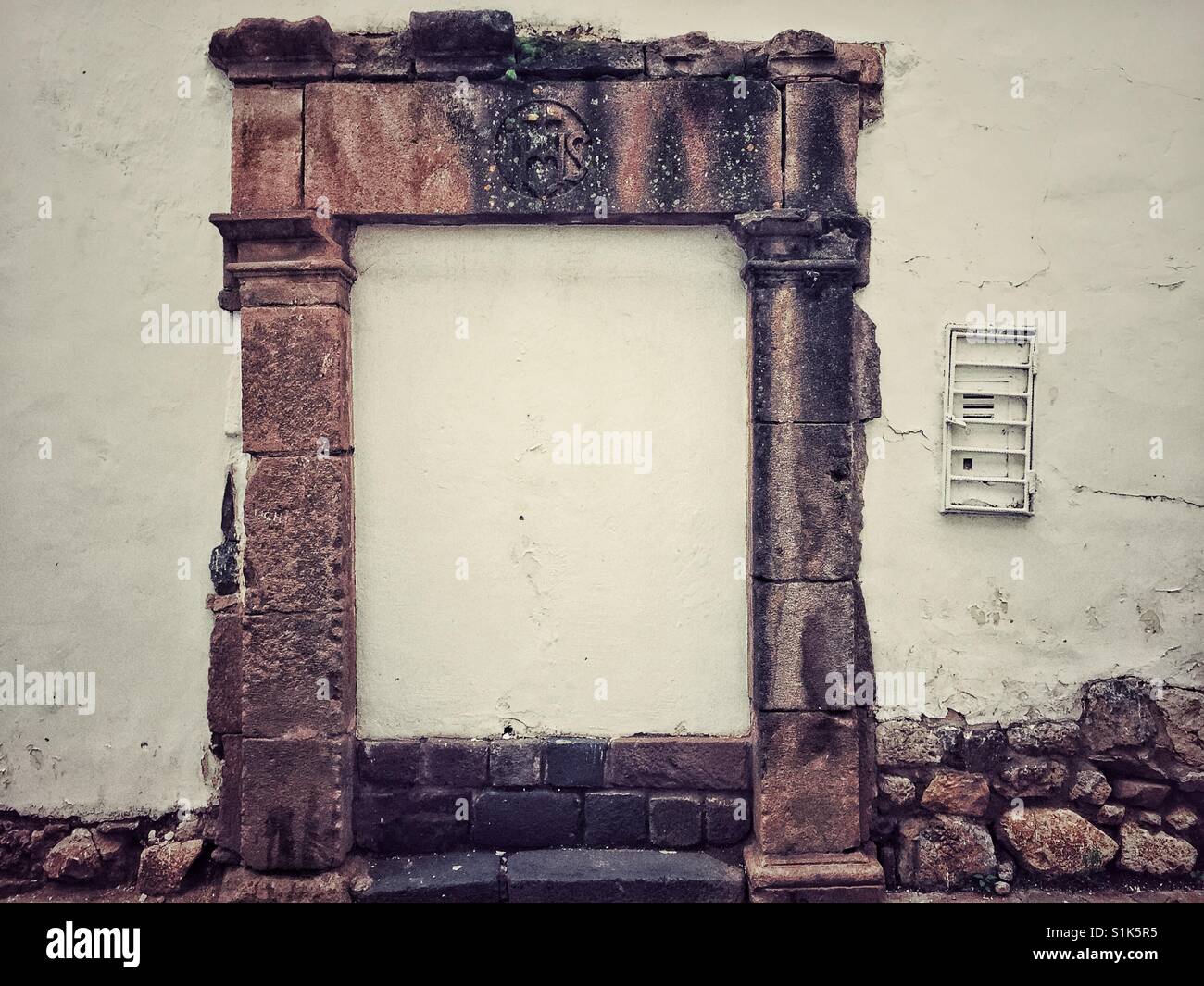 Stone Frieze and door frame attached to a wall with no door in Cusco, Peru - Smartphone Captured Stock Image