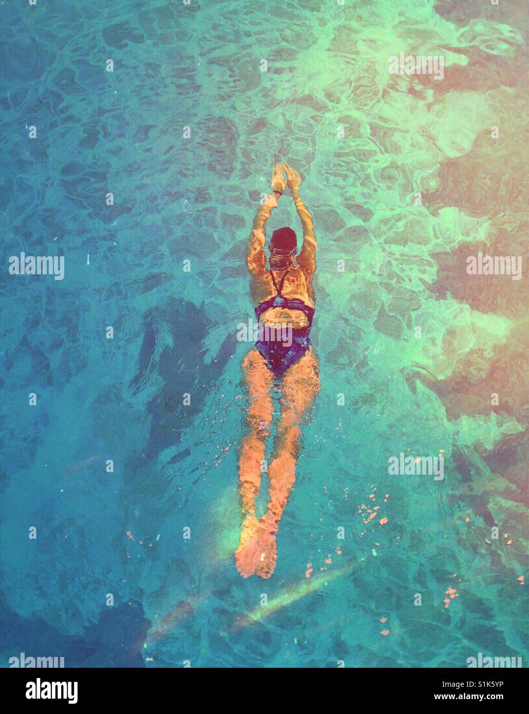 Woman swimming in outdoor swimming pool. Room for copy. - Smartphone Captured Stock Image