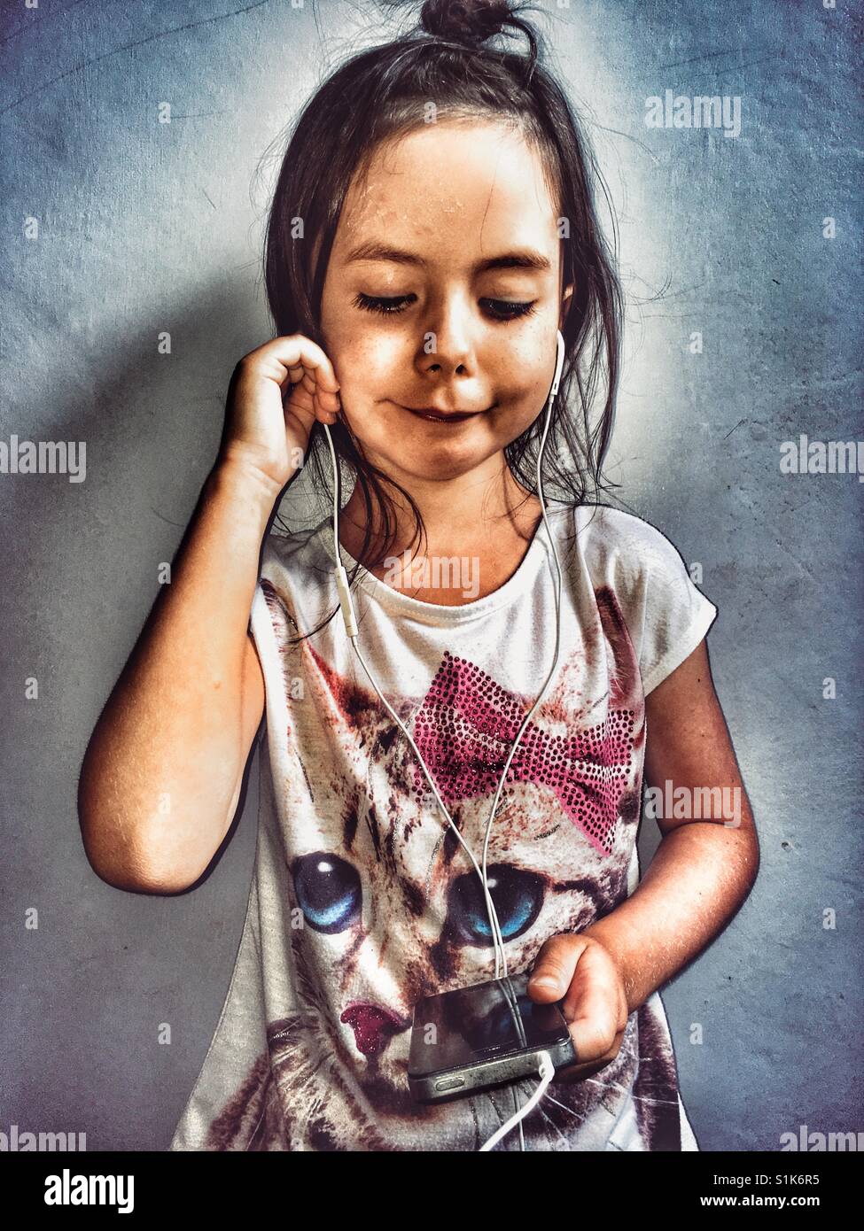 5-year old girl viewing online content on a smartphone - Smartphone Captured Stock Image