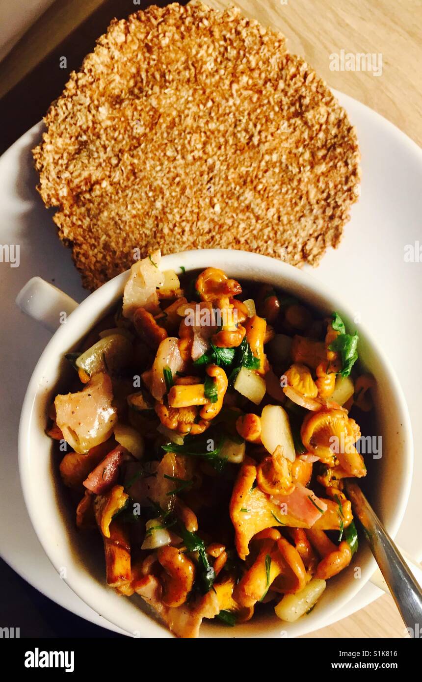 Stir fried Chanterelle mushrooms with garlic served with traditional Latvian bread. Stock Photo
