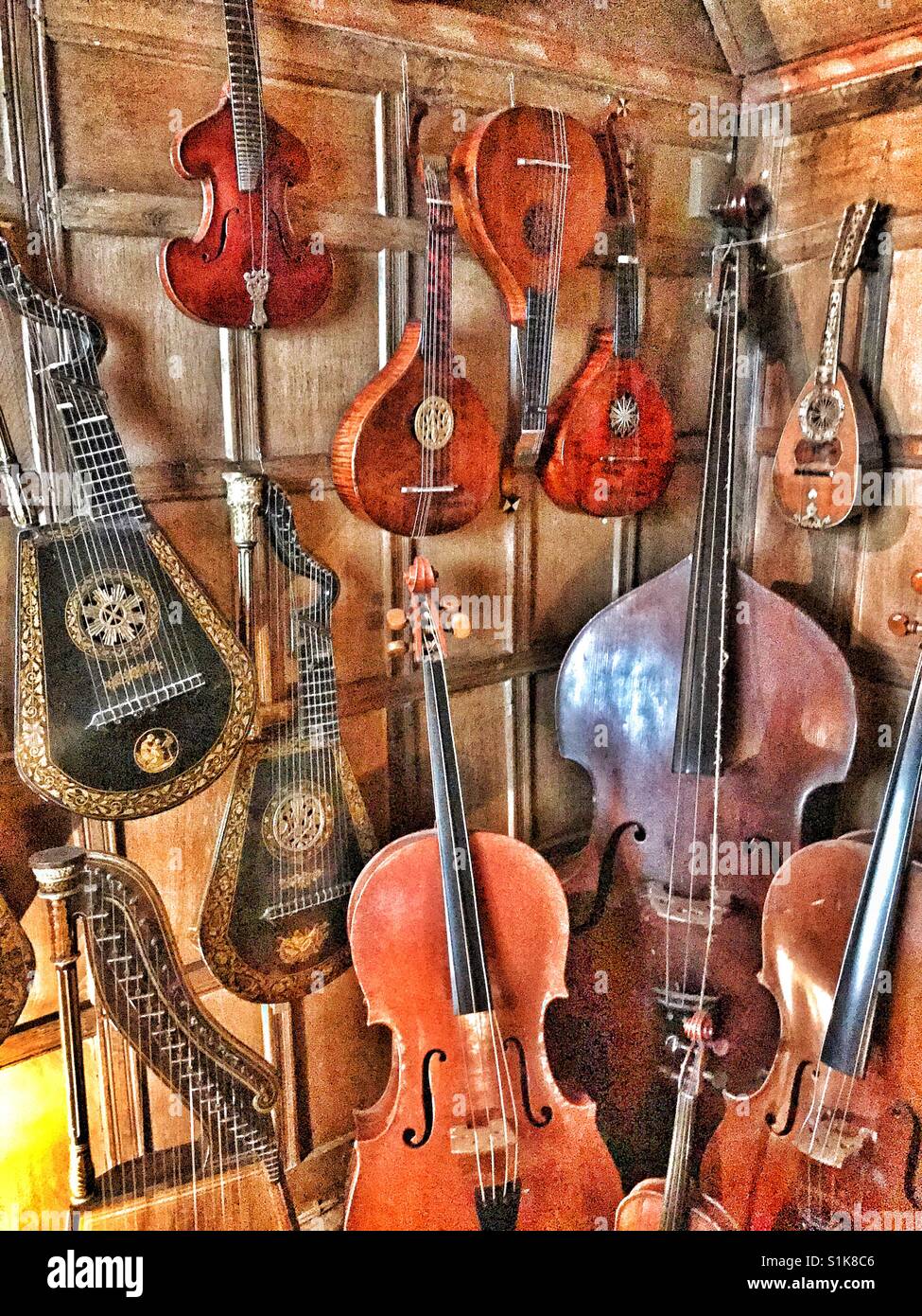 A collection of string musical instruments in the corner of a house