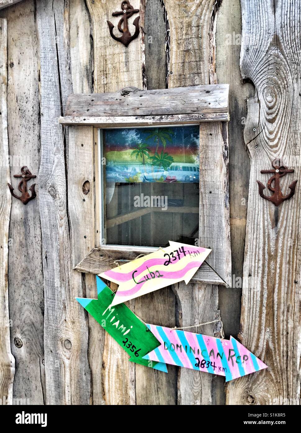 Wooden hut displaying colourful directional signs. - Smartphone Captured Stock Image